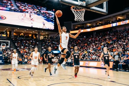 An image of the word basketball as defined by a game played by two teams of usually five players each on a rectangular court having a raised basket or goal at each end, points being scored by tossing the ball through the opponent's basket.