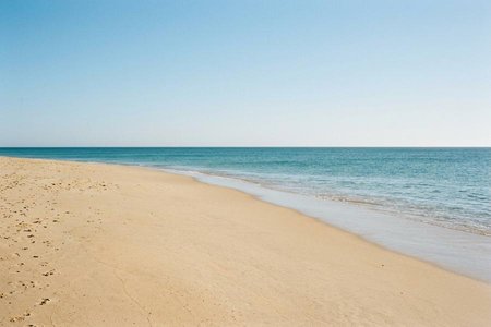 An image of the word beach as defined by an expanse of sand or pebbles along a shore.