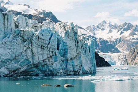 An image of the word glacier as defined by an extended mass of ice formed from snow falling and accumulating over the years and moving very slowly, either descending from high mountains, as in valley glaciers, or moving outward from centers of accumulation, as in continental glaciers.