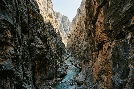 An image of the word gorge as defined by a narrow cleft with steep, rocky walls, especially one through which a stream runs.