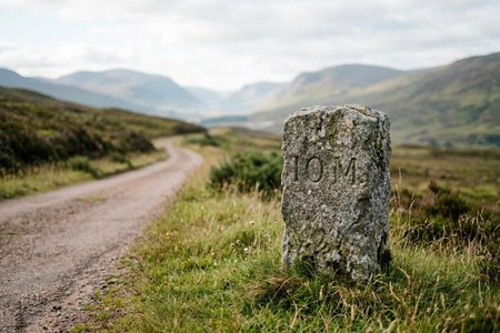 An image of the word milestone as defined by a stone functioning as a milepost.